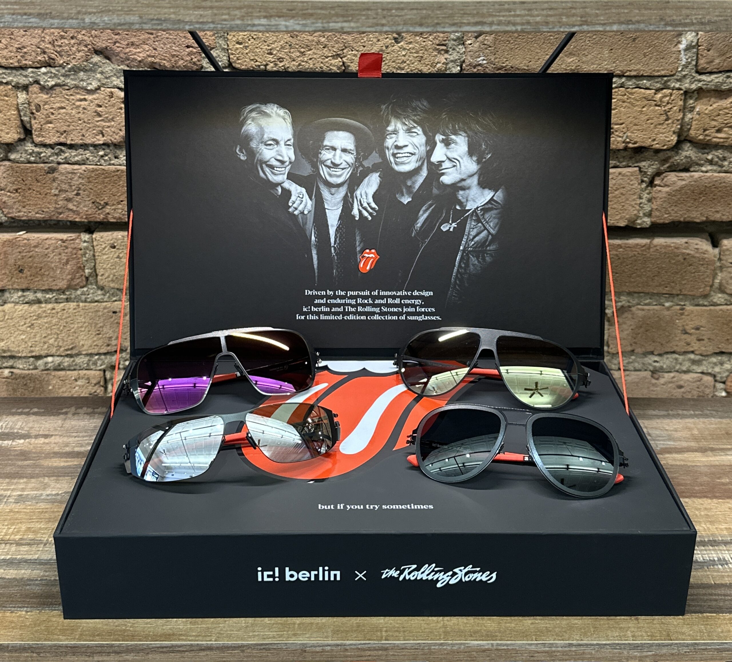 sunglasses display with four pairs of sunglasses and a photo of The Rolling Stones band members.